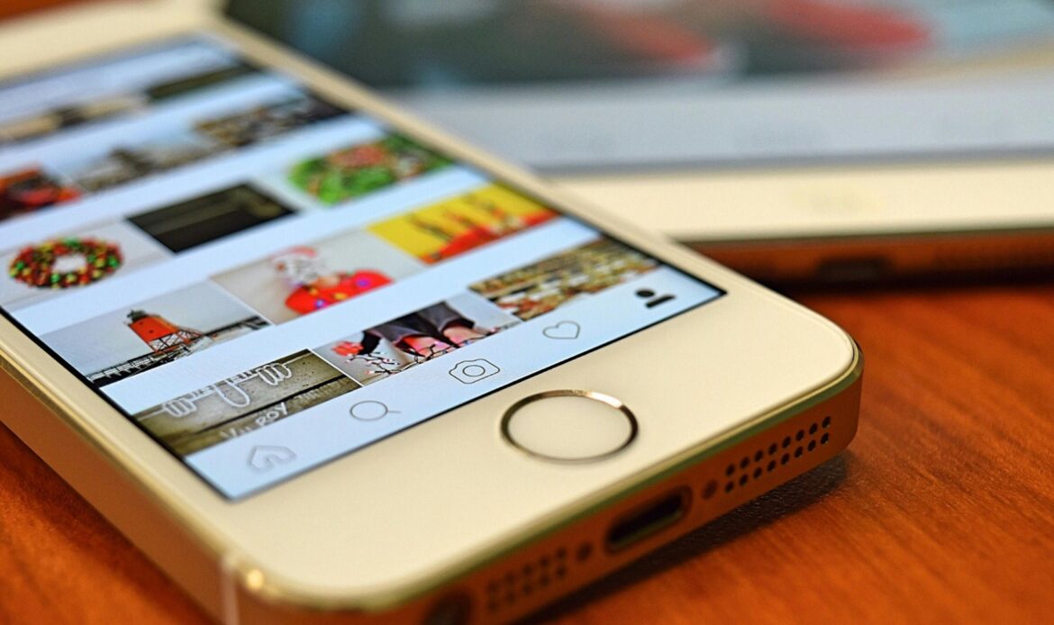 A close-up view of a smartphone displaying the Instagram app on a wooden surface.